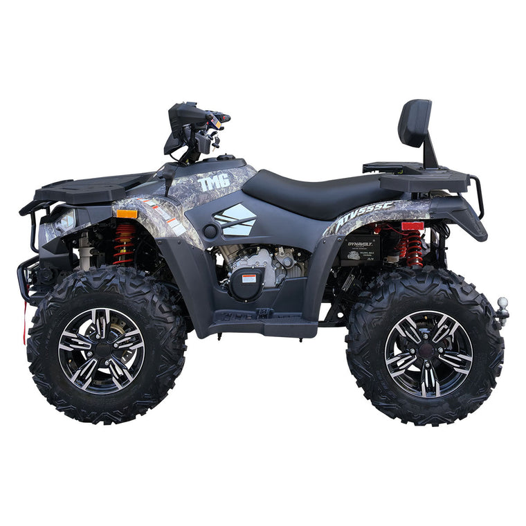 Side profile of gray camo TMG ATV showing seat, racks, wheels.