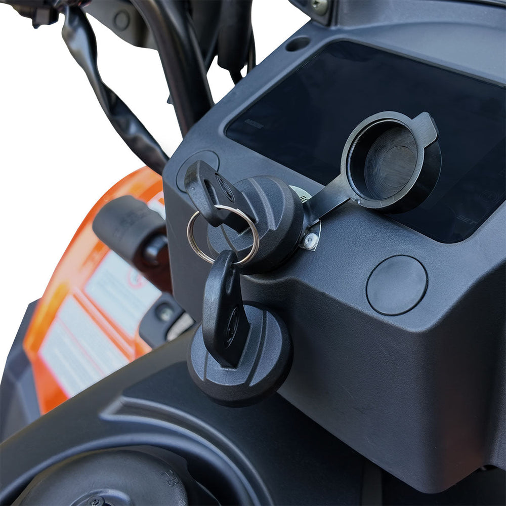 Ignition key and small storage recess on dashboard of ATV.