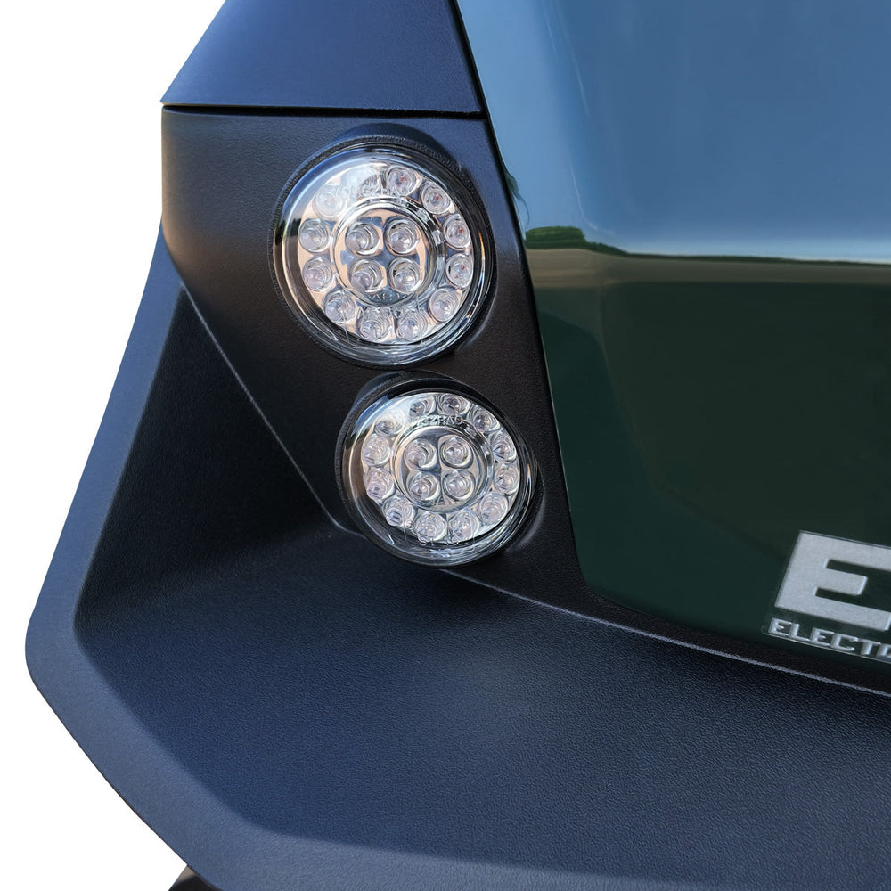 Rear dual circular LED tail lights on green ATV rear panel.